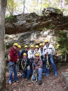 Group of zipliners in front of a grey rock bluff